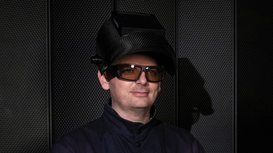 A welder wearing laser welding safety glasses and a laser welding helmet