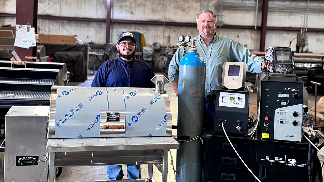Welders posing with a grill built using handheld laser welding